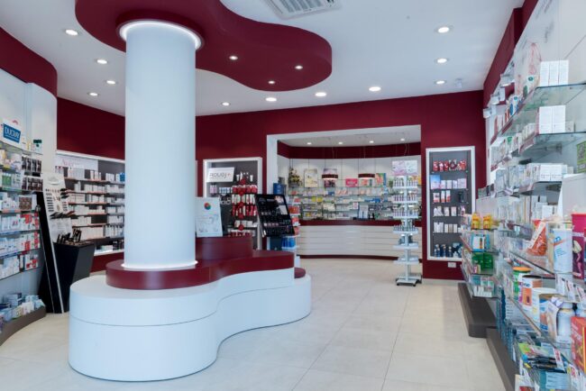 Vista interna della Farmacia del Corallo a Livorno con pilastro centrale e soffitto color corallo