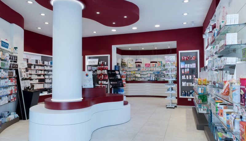 Vista interna della Farmacia del Corallo a Livorno con pilastro centrale e soffitto color corallo